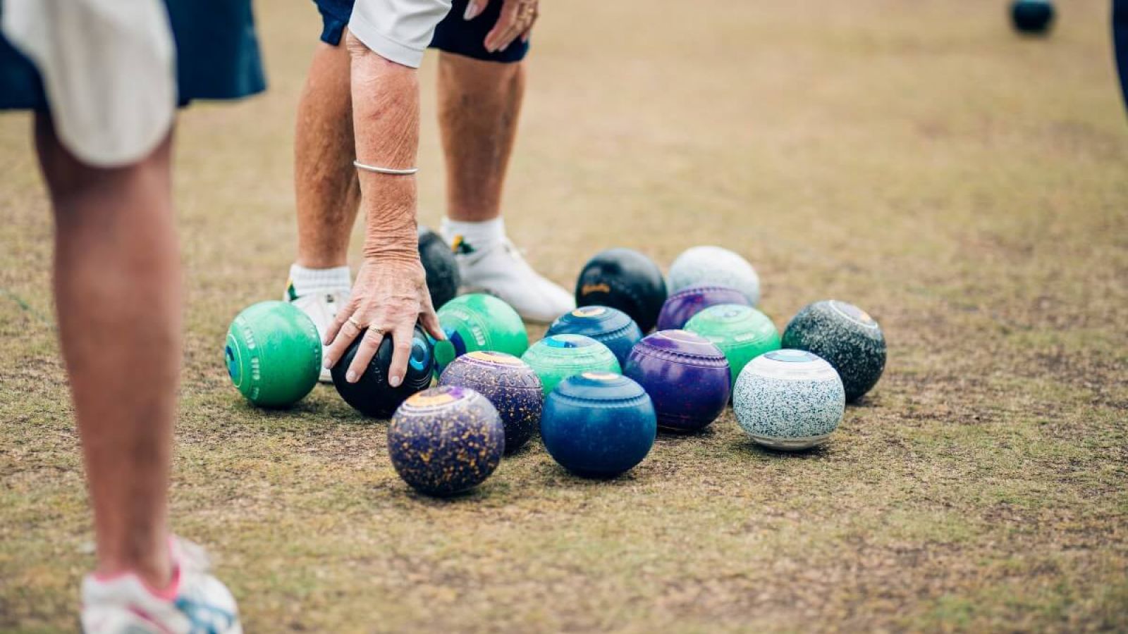 Parksville Lawn Bowling Club member picking up bowl