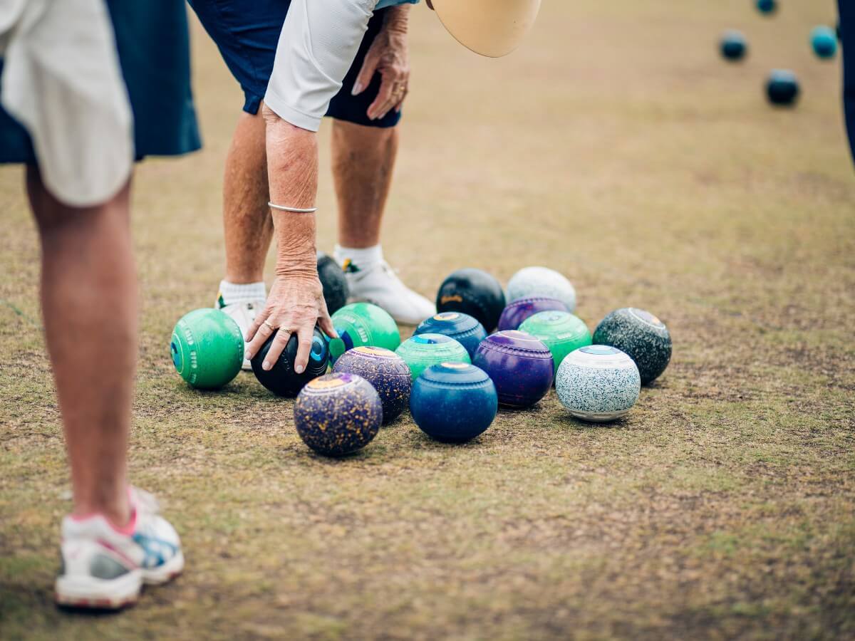 Parksville Lawn Bowling Club member picking up bowl
